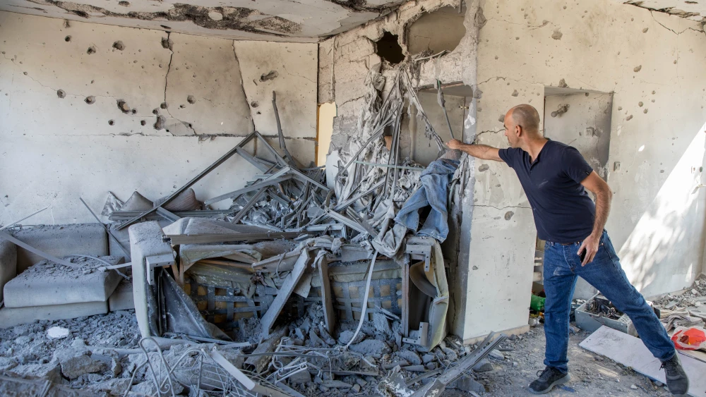 A man stands inside a house that was hit by a rocket fired from the Gaza Strip in the southern Israeli city of Ashkelon on Nov. 13, 2018. Photo by Nati Shohat/Flash90.