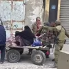 Israeli soldiers help an elderly Gazan woman, November 2023.