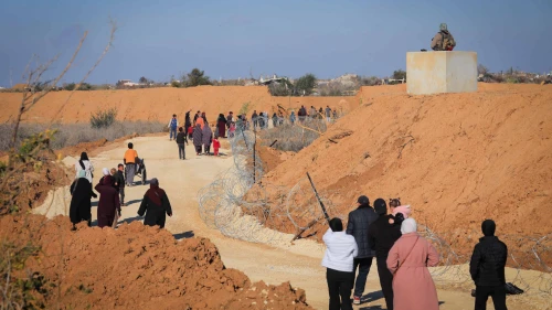 Gazans walk alongside an Israeli army post in northern Gaza, Jan. 28, 2025. Photo by Ali Hassan/Flash90.