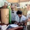 A bar mitzvah boy reads his Torah portion at the Western Wall in Jerusalem. Credit: Peter van der Sluijs via Wikimedia Commons.