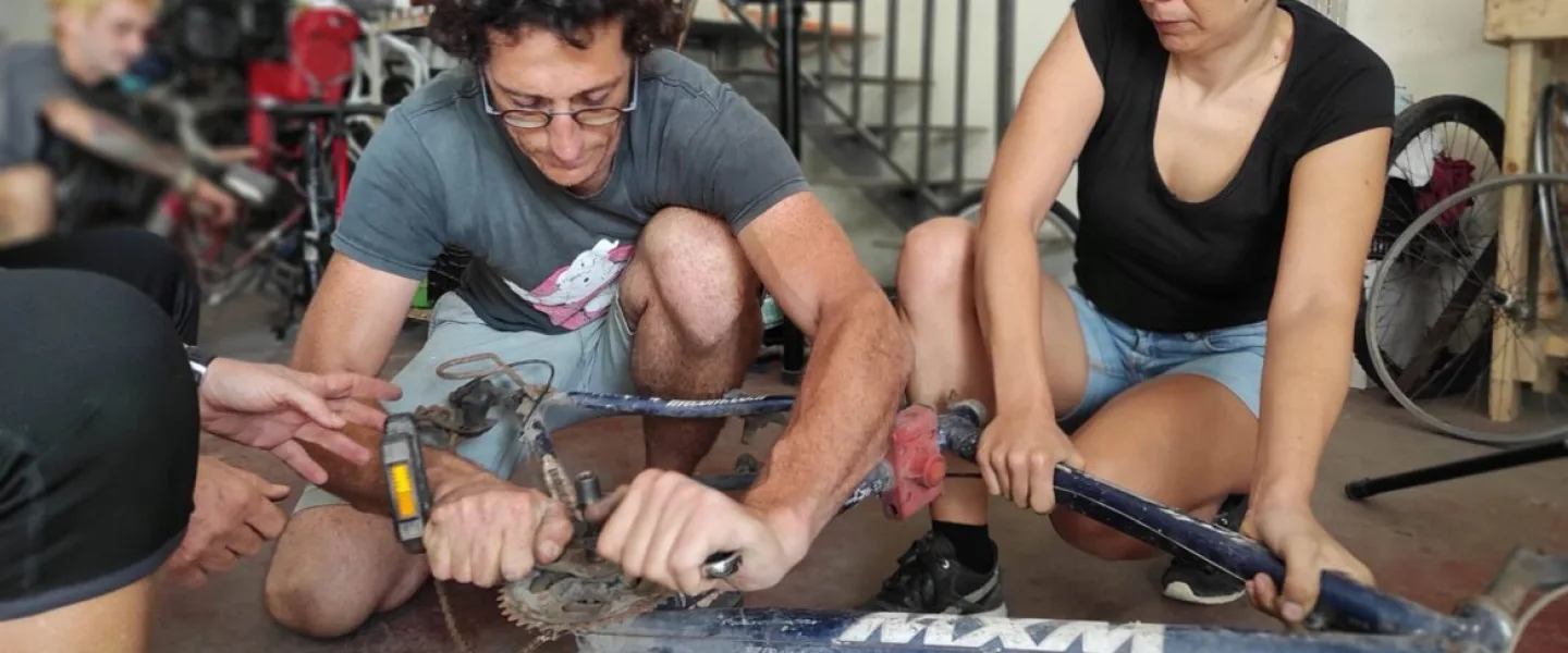 Nathanael Singer showing workshop visitors how to fix a bicycle. Photo courtesy of Pnimeet.
