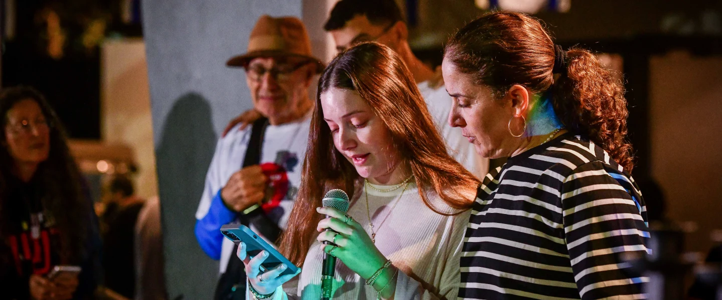 Chen Goldstein-Almog and her daughter Agam light Chanukah candles together with other members of Kibbutz Kfar Aza in Shefayim, Dec. 10, 2023. Photo by Avshalom Sassoni/Flash90.