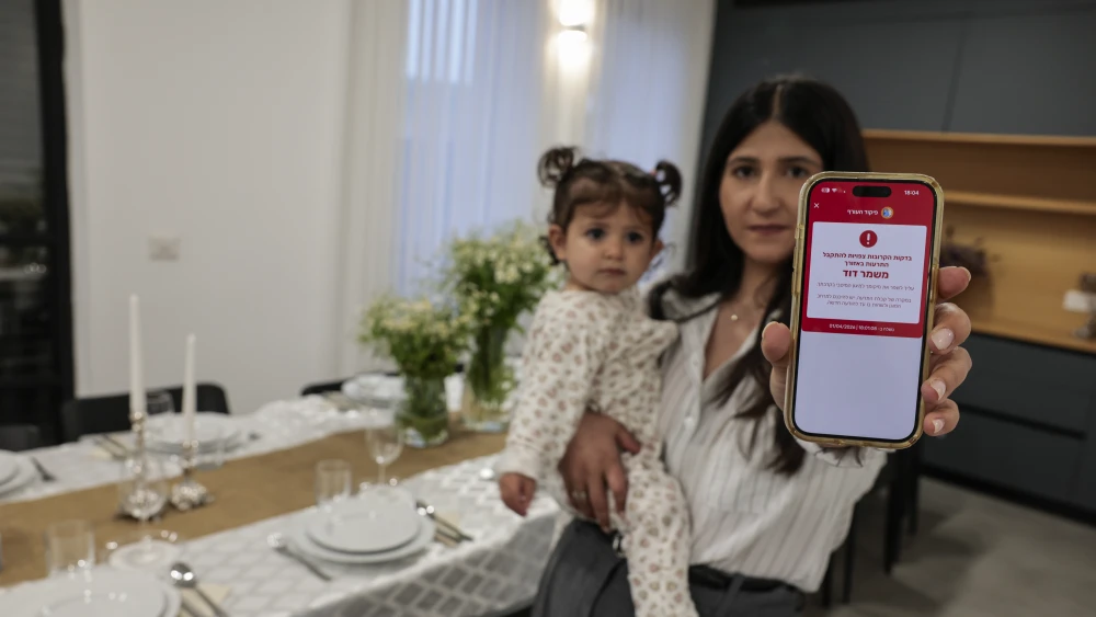 An Israeli woman shows a missile alert notification on her mobile phone.