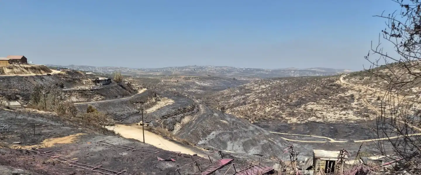 A view of the damage caused by wildfire burns through the Samaria community of Havat Gilad on July 18, 2026. Credit: Courtesy of AFJS.