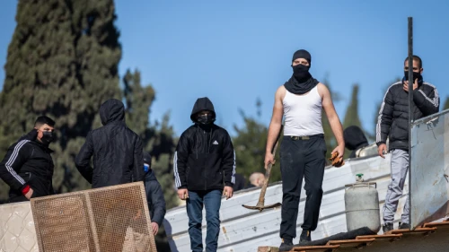 Palestinians with gas cylinders stand on a rooftop of a house being evacuated by Israeli special forces, in the eastern Jerusalem neighborhood of Sheikh Jarrah, on Jan. 17, 2022. Photo by Yonatan Sindel/Flash90.