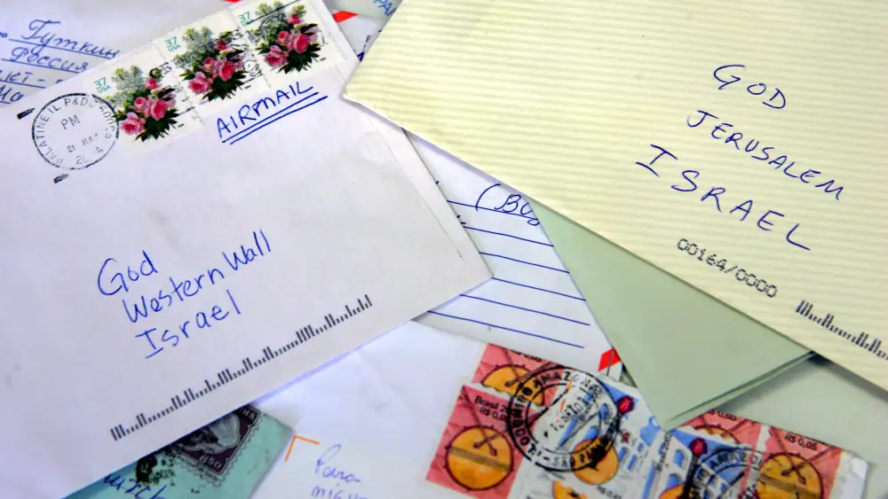 Letters to God are scattered on the sorting table at an Israeli post office to be placed between the ancient stones of the Western Wall later in the day in Jerusalem, June 15, 2005. Photo by David Silverman/Getty Images.