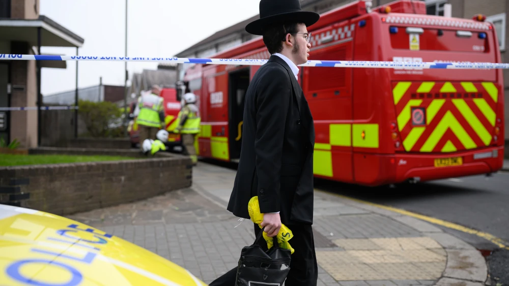 A member of the Jewish Orthodox community walks around the cordon as fire services continue to monitor the scene after four Hatzolah ambulances were set on fire overnight next to Machzike Hadath Synagogue, on March 23, 2026 in London, England. Photo by Leon Neal/Getty Images.