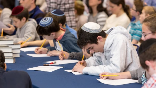 Students write feverishly at Chidon HaTanakh at Manhattan Day School. Photo by David Khabinsky.