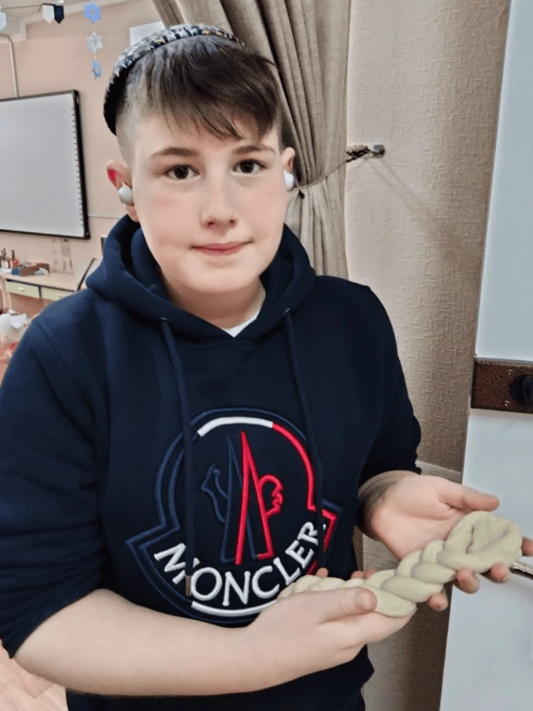 A camp participant makes challah prior to the start of Shabbat. Credit: JRNU.