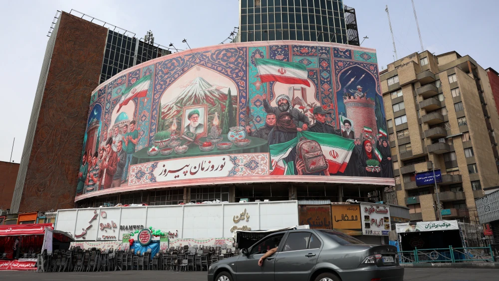 A car drives past a giant billboard with a portrait of Iran's slain supreme leader, Ayatollah Ali Khamenei, at Tehran's Valiasr Square, March 22, 2026. Photo by AFP via Getty Images.