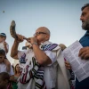 An Israeli blows a shofar as others perform Tashlich on the afternoon of Rosh Hashanah at the beach in Tel Aviv, on Sept. 10, 2018. Photo by Yonatan Sindel/Flash90.