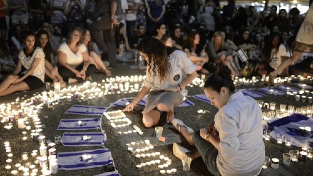 Click photo to download. Caption: Israelis light candles in Tel Aviv's Rabin Square on Monday as they mourn the news of the death of three abducted Jewish teenagers. Israeli forces found the bodies of the three missing teenagers on Monday after a nearly three-week-long search. Credit: Tomer Neuberg/Flash90.