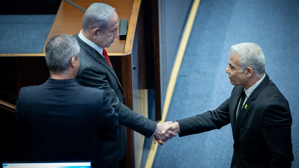 Israeli Prime Minister Benjamin Netanyahu speaks with opposition leader Yair Lapid at a plenum session for the Knesset's 75th birthday, in the assembly hall of the parliament in Jerusalem on Jan, 24, 2024. Photo by Yonatan Sindel/Flash90.