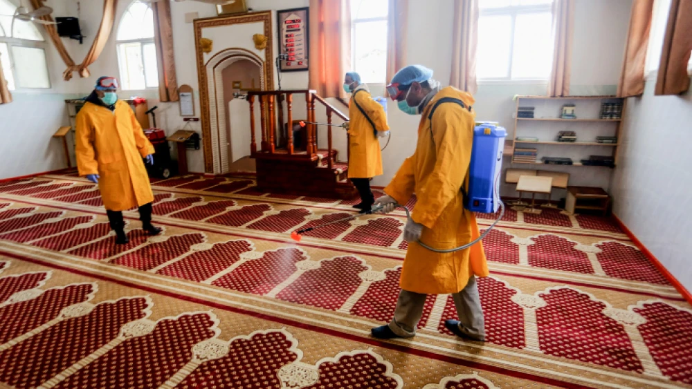 Palestinian health workers spray disinfectant in a mosque as a precaution against COVID in Rafah, in the southern Gaza Strip, on March 22, 2020. Photo by Abed Rahim Khatib/ Flash90.