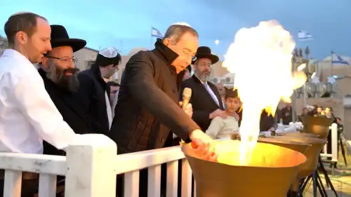 U.S. Ambassador Thomas Nides lights a Hanukkah flame at the Western Wall Plaza as Chief Rabbi of Israel David Lau (standing with the child) and Rabbi of the Western Wall and holy sites Shmuel Rabinowitz (directly behind Nides) look on, Dec. 25, 2022. Credit: The Western Wall Heritage Foundation.