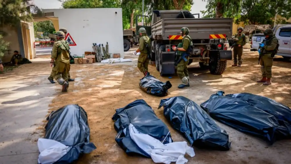 IDF soldiers remove the corpses of civilians in Kibbutz Kfar Aza, near the Gaza Strip, Oct. 10, 2023. Photo by Chaim Goldberg/Flash90.