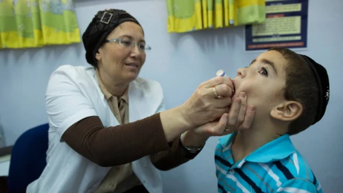 A boy is vaccinated against polio in the Neve Yaakov neighborhood of Jerusalem, Sept. 10, 2013. Photo by Yonatan Sindel/Flash90.