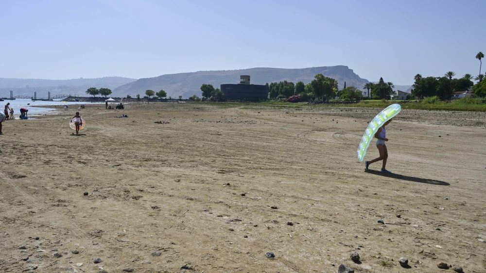 Israelis walk where water used to be, due to a winter with very low rainfall, Kibbutz Ginosar, Sea of Galilee, Oct. 4, 2025. Photo by Michael Giladi/Flash90.