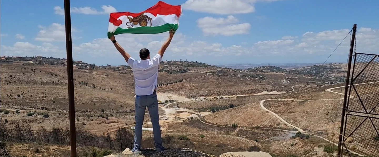 Ahmad Batebi, an Iranian non-Jewish activist and journalist waving the “Sun and Lion” Iranian flag that was used during the Pahlavi dynasty, in Israel. Credit: Courtesy.