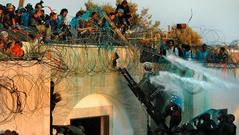 Israelis barricaded on a roof throw water, rubbish and chemicals at approaching security forces who are about to evacuate them from Kfar Darom in the Gaza Strip. Photo by Yossi Zamir/Flash90.
