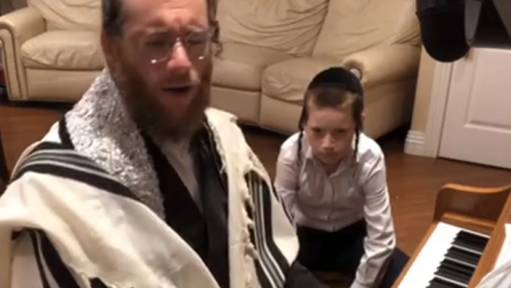 Yaakov Lemmer, cantor at Lincoln Square Synagogue in New York City, plays the piano and sings traditional melodies welcoming the onset of Shabbat. Source: Screenshot.
