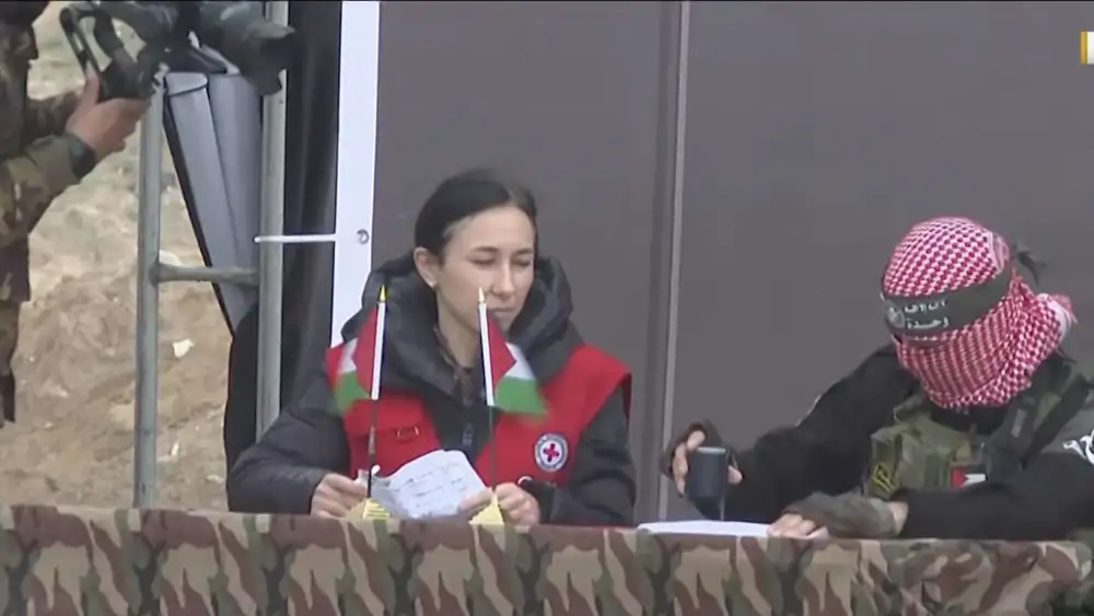 A Red Cross official on stage during the signing "ceremony" to release the bodies of four Israeli hostages, Feb. 20, 2025. Credit: Quds News Network.