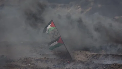 Palestinians display a flag with a swastika in the middle during Gaza border protests in April 2018. Credit: IDF via Twitter.