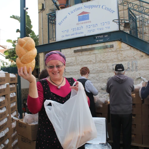 Volunteer Rita Lewy displays a loaf of challah at the Terror Victims Support Center. Credit: Courtesy.