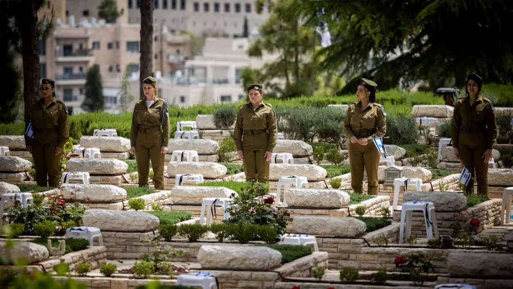 Soldiers place flags on the graves of fallen comrades at Mount Herzl Military Cemetery in Jerusalem, April 23, 2023. Photo by Yonatan Sindel/Flash90.