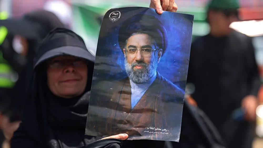 An Iranian pilgrim displays a portrait of Iran's Supreme Leader Mojtaba Khamenei after crossing the Iraq-Iran border at Zurbatiyah on July 29, 2026. Photo by Ahmad al-Rubaye/Getty Images