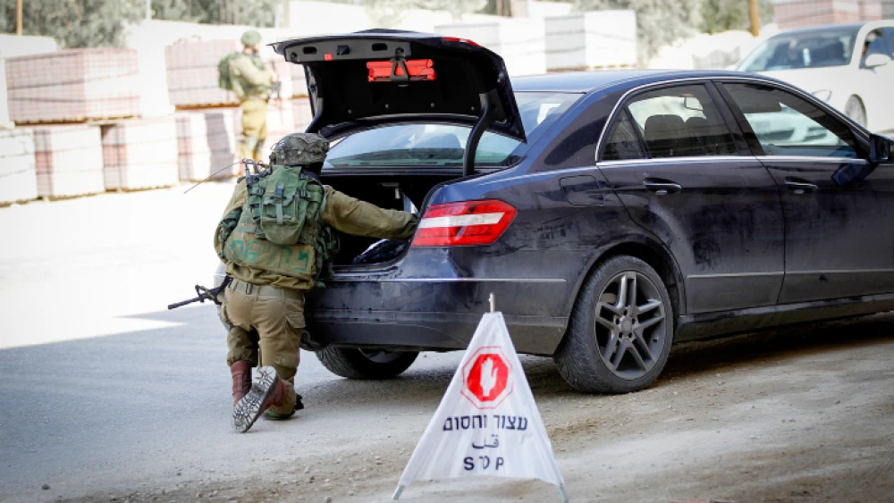An Israeli soldier searches a vehicle in Hebron on Nov. 4, 2016. Photo by Wisam Hashlamoun/Flash90.