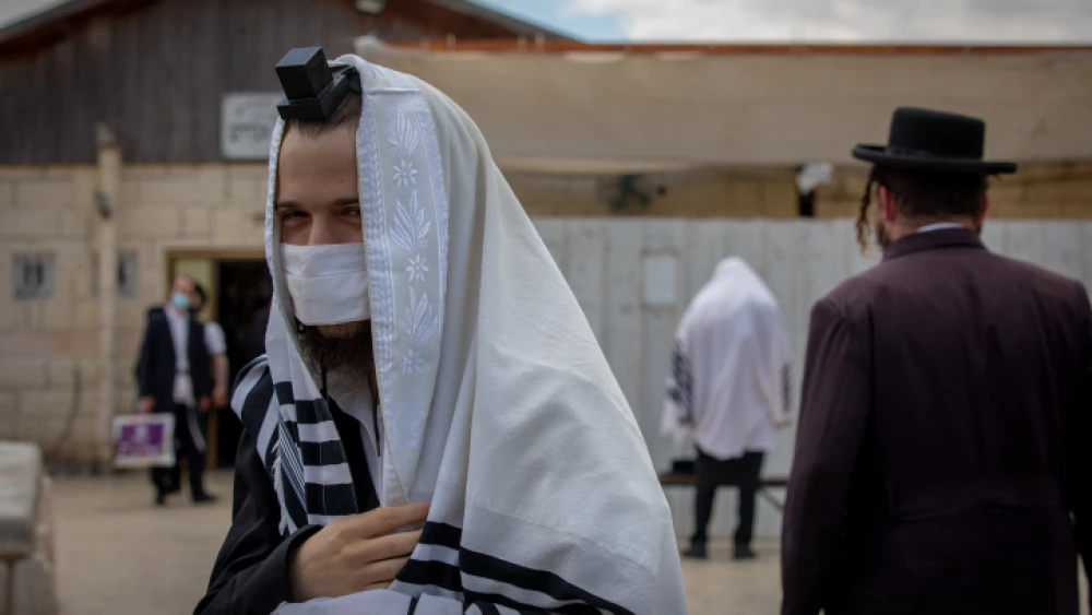 Jewish men pray outside a synagogue in Beitar Illit, Israel, on July 9, 2020. Photo by Nati Shohat/Flash90.