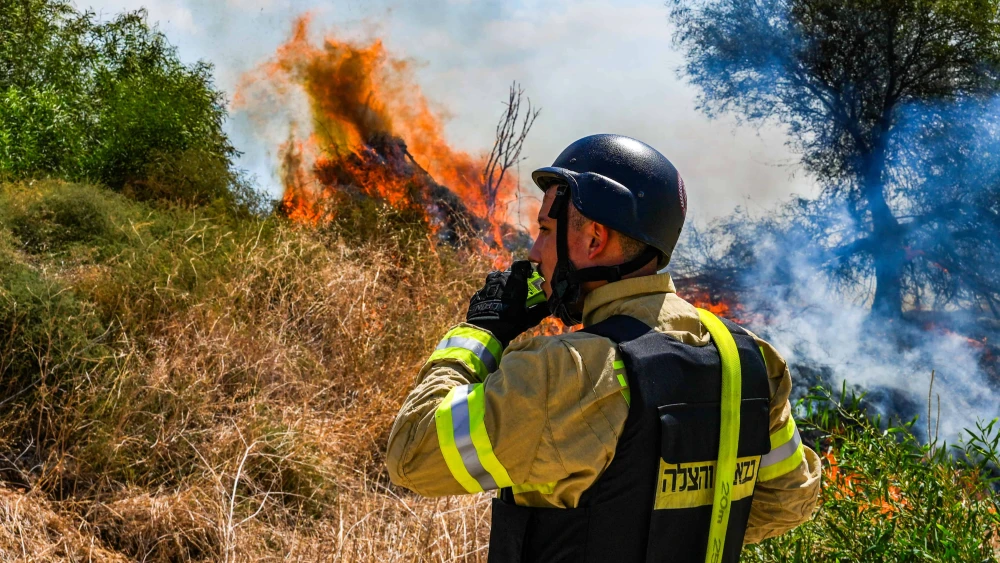 A Firefighter at a wildfire following a missile attack from Lebanon, near Kibbutz Snir in the Galilee panhandle, Sept. 16, 2024. Photo by Ayal Margolin/Flash90.