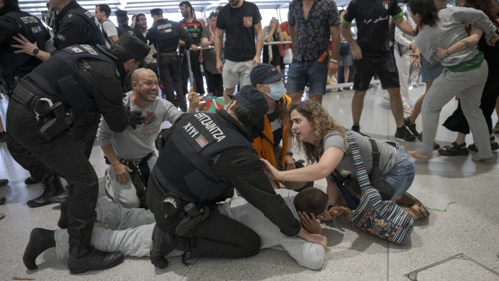 Basque police officers detain members of the Global Sumud Flotilla upon their arrival at Bilbao airport on May 23, 2026. Photo by Idurre Etxaburu / AFP via Getty Images.