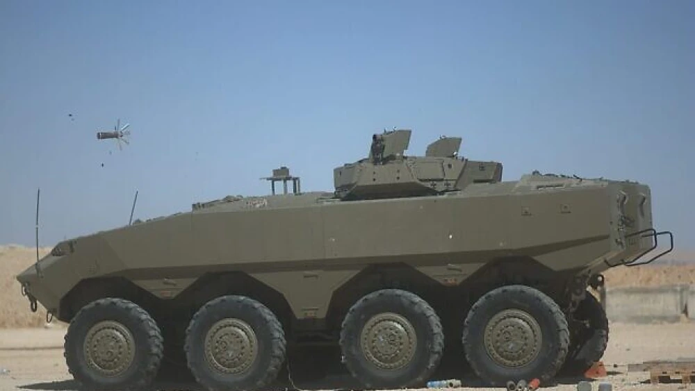 The Iron Fist active defense system mounted on an Eitan APC fires a projectile to intercept an incoming antitank missile. (Israeli Defense Ministry)