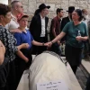 Ari Fuld's wife, Miriam, and son hold hands over his enshrouded body, wrapped in a tallit and awaiting burial at the Kfar Etzion cemetery in Judea. Photo by Gershon Elinson/Flash90.