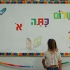 A small child reads a board welcoming her to the first grade at Pola Ben-Gurion School in Jerusalem, Aug. 31, 2004. Credit: Flash90.