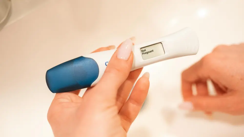 A woman holding a negative pregnancy test. Credit: RDNE Stock Project.