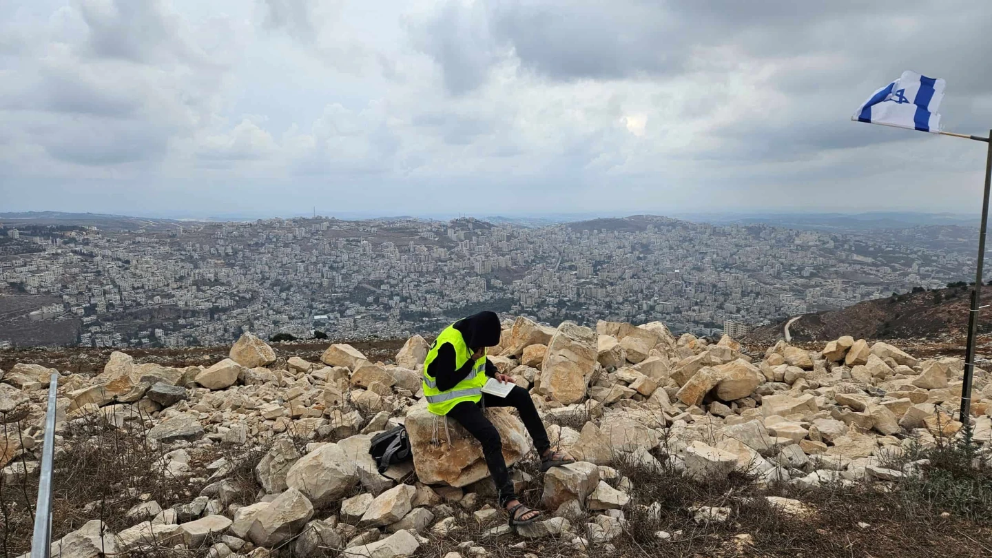 A yeshiva student learning Talmud overlooking Nablus during a tour at Joshua's Altar on Mt. Ebal in Samaria. Photo: Benjamin Sipzner.