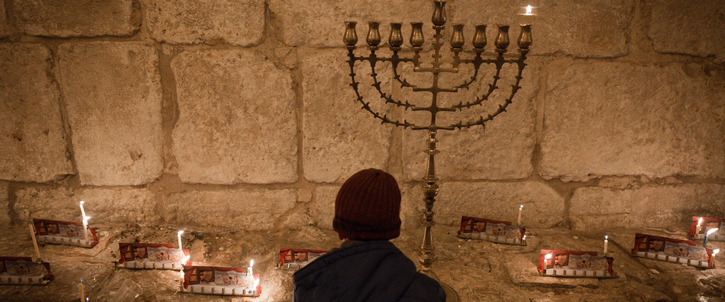 Candles on the first night of the Jewish holiday of Hanukkah, in the Jerusalem neighborhood of Mea Shearim. Hanukkah, also known as the “Festival of Lights,” is an eight-day Jewish holiday commemorating the rededication of the Holy Temple. The festival is observed by the kindling of the lights of a “hanukkiyah,” a nine-branched candelabrum with one additional light being lit on each night of the holiday. Dec. 24, 2016. Photo by Sebi Berens/Flash90.