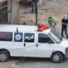 Palestinians throw rocks from behind an ambulance during a riot in Qalandiya. Credit: IDF.