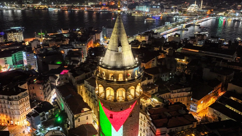 Istanbul's Galata Tower is lit up with the flag of the Palestine Liberation Organization, Oct. 7, 2025. Photo by Yasin Akgul/AFP via Getty Images.