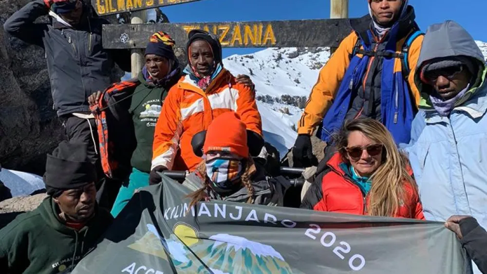 Hikers and their porters pose at the top of Mount Kilimajaro. Credit: Friends of Access Israel.