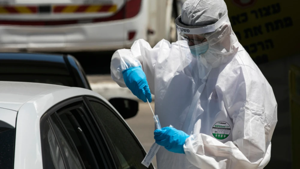 Magen David Adom medical workers test Israelis at a drive-through coronavirus testing site in Jerusalem on May 31, 2020. Photo by Olivier Fitoussi/Flash90.