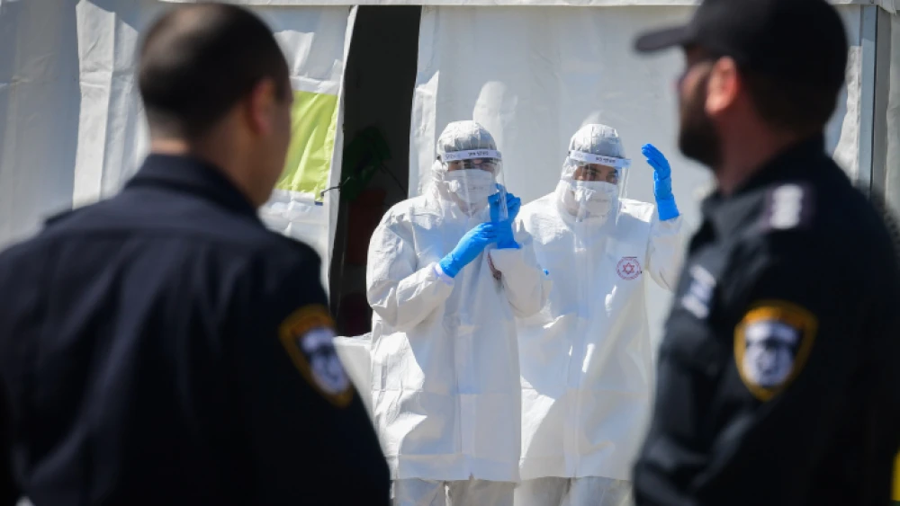 Magen David Adom medical team members in protective gear at a drive-through COVID-19 testing site in Tel Aviv, on March 22, 2020. Photo by Flash90.