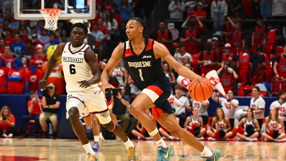 Cam Crawford #1 of the Duquesne Dukes advances the ball away from Enoch Cheeks #6 of the Dayton Flyers during the first half of a game at UD Arena, Feb. 15, 2025, Dayton, Ohio. Photo by Ben Jackson/Getty Images.
