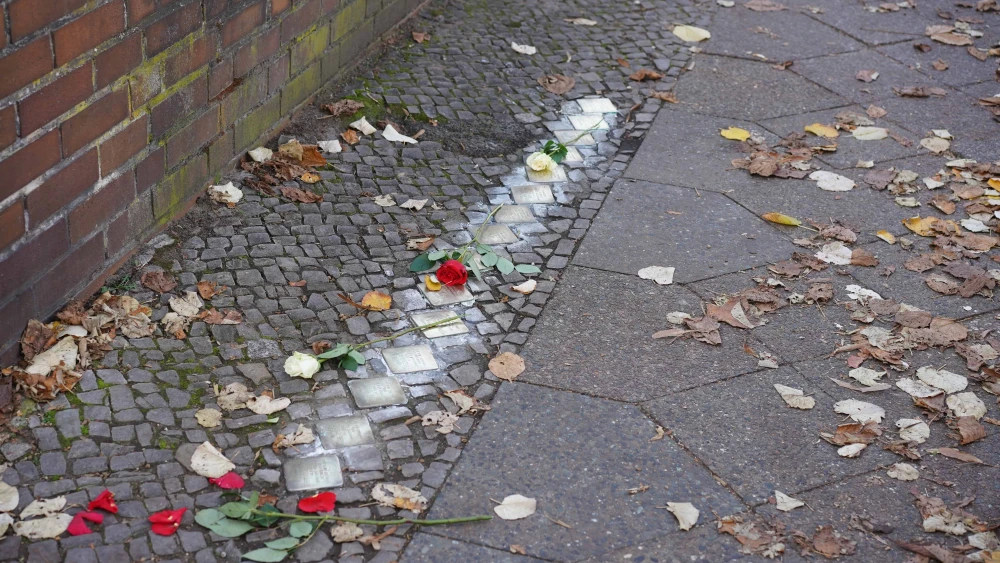 Freshly polished Stolpersteine (“stumbling stones”) in Berlin decorated with flowers marking the anniversary of Kristallnacht on Nov. 8, 2022. Credit: Achim Wagner/Shutterstock.