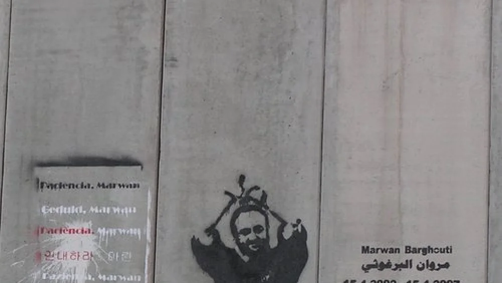 A portrait of Palestinian terrorist Marwan Barghouti on the security fence between Israel and the disputed territories. Credit: Eman via Wikimedia Commons.