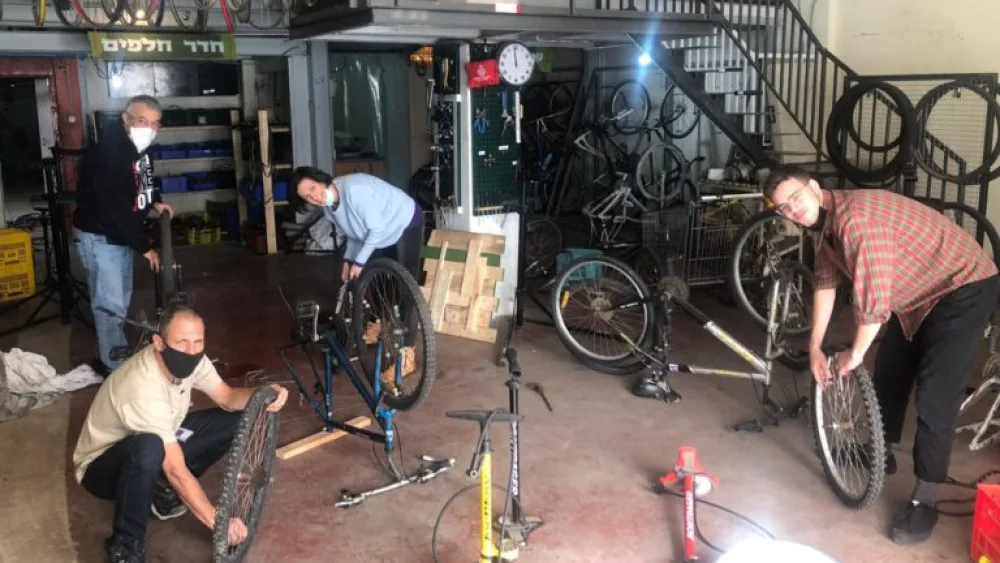 People repairing bicycles at the workshop in Jaffa. Photo courtesy of Pnimeet