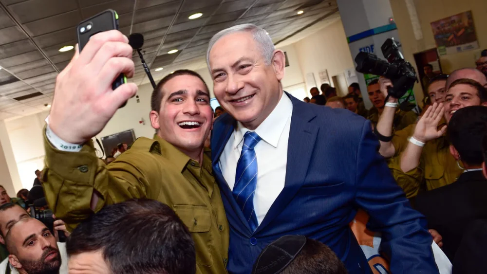A lone soldier in the Israel Defense Forces snaps a selfie with Israeli Prime Minister Benjamin Netanyahu, who made a stop during “Yom Siddurim,” or “personal errands day,” on Jan. 24, 2018. Photo by Shahar Azran.